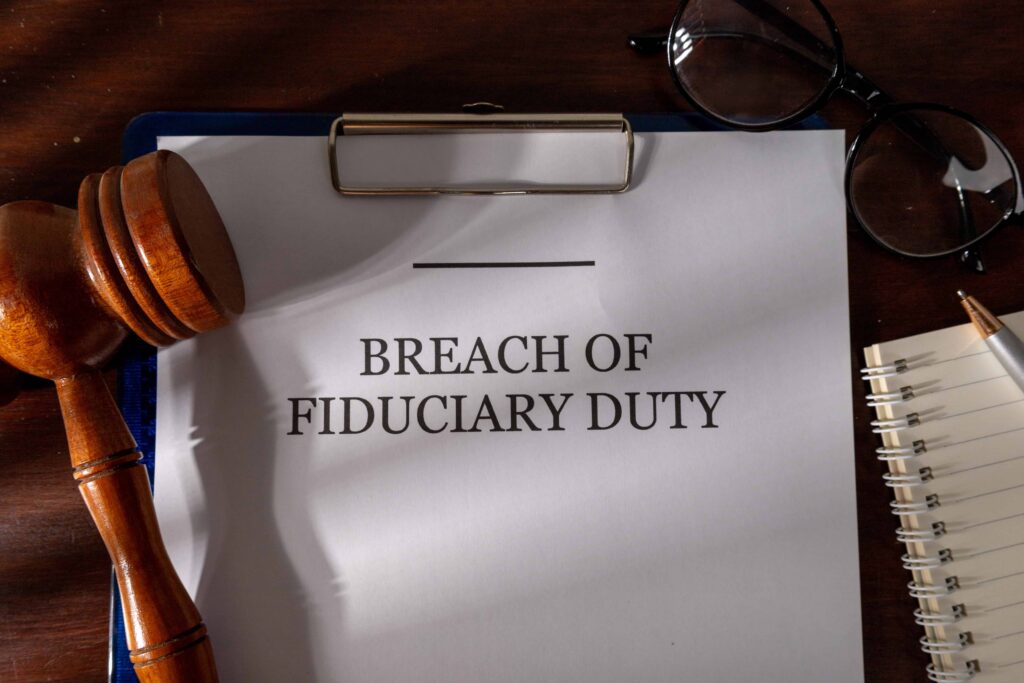 Document titled “Breach of Fiduciary Duty” on clipboard with gavel and eyeglasses, representing business litigation and legal dispute. Document titled “Breach of Fiduciary Duty” on clipboard with gavel and eyeglasses, representing business litigation and legal dispute.