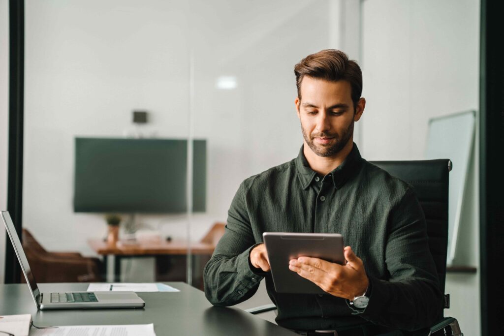 Professional male lawyer using tablet in modern office, reviewing legal case information and digital documents. Professional male lawyer using tablet in modern office, reviewing legal case information and digital documents.