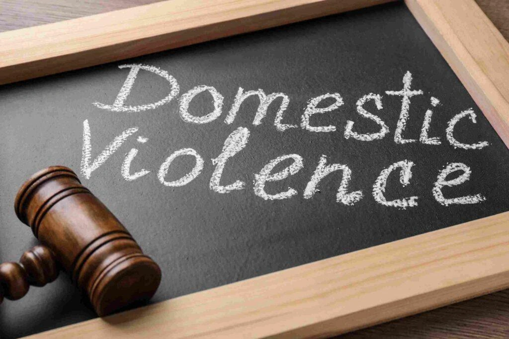 Judge’s gavel on a chalkboard with the words “Domestic Violence,” representing legal protection, abuse awareness, and domestic violence law.