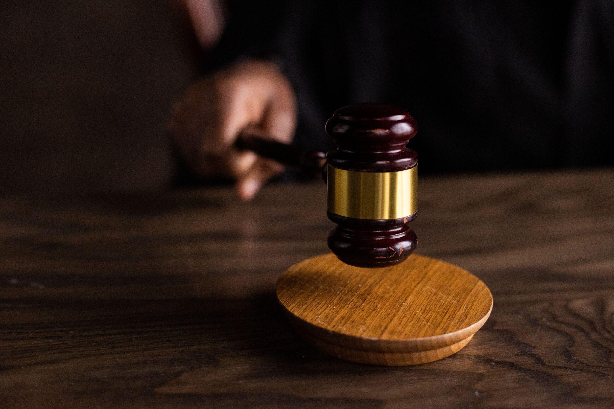 Judge's gavel resting on a wooden sound block, symbolizing courtroom proceedings and legal decisions.